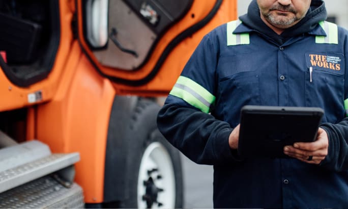 Man looking at ipad with truck in background.