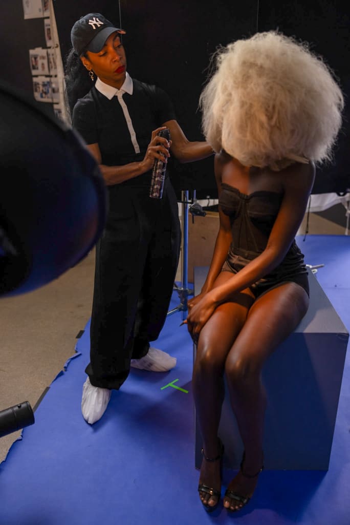 A hairstylist applies hairspray.