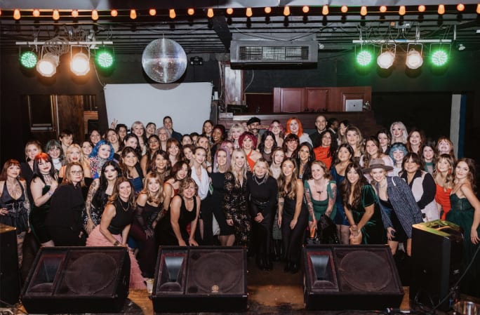 A large group of employees in cocktail attire at an Urban Betty holiday party.