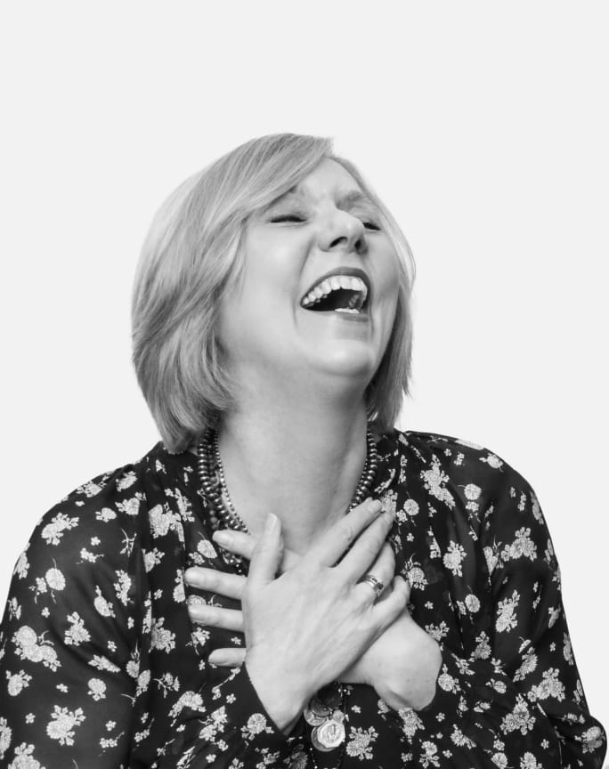 Virginia Meyer, co-owner of Fourteen Jay and the Dean of Aveda Business College expresses joy in this black and white headshot.
