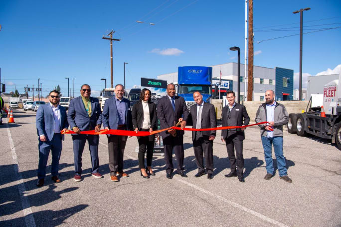 Dignitaries at a ribbon cutting for a new truck charging depot.