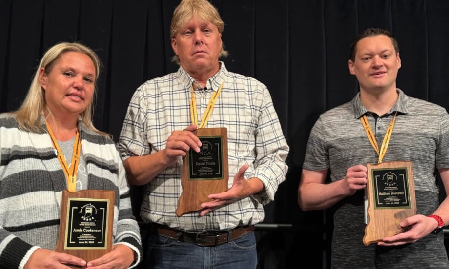 Three award winners pose with their awards.