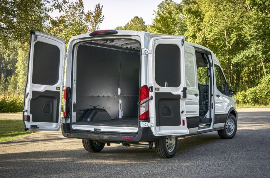 A white Ford Transit van rear three-quarter view with back doors and side door open.