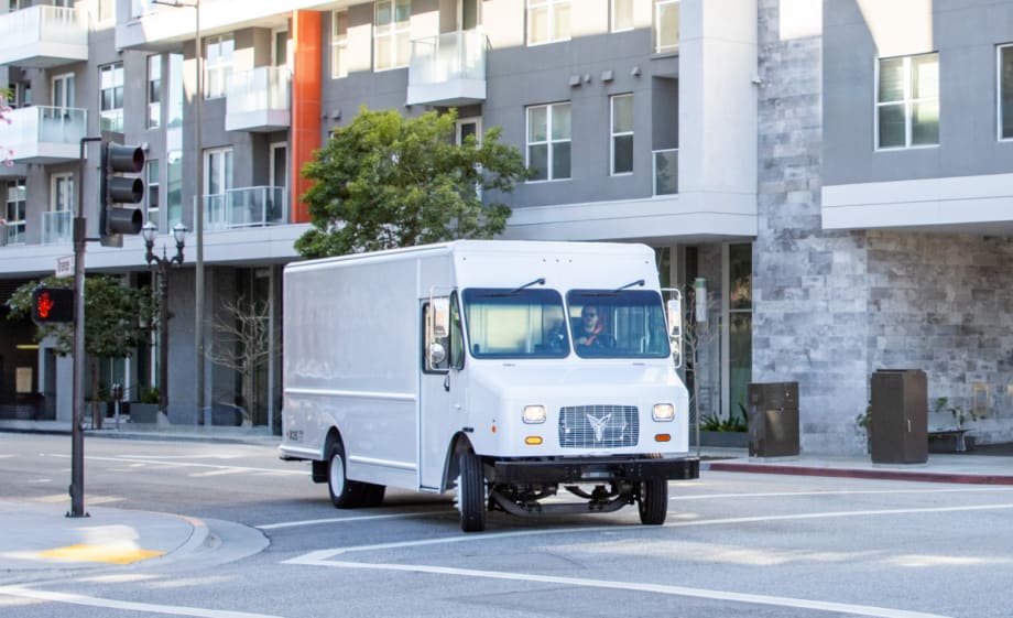A white 2024 Xos Stepvan on a city street