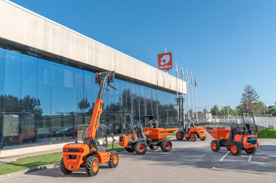 Orange small construction vehicles including forklifts and small dump trucks are parked outside and office.