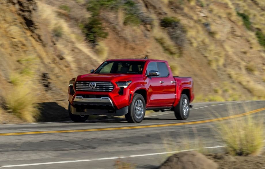 Red Toyota Tacoma driving down the street.