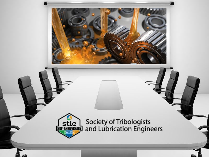 A stark white boardroom table, black chairs on either side, and a projection screen with an image of oil flowing over gears.