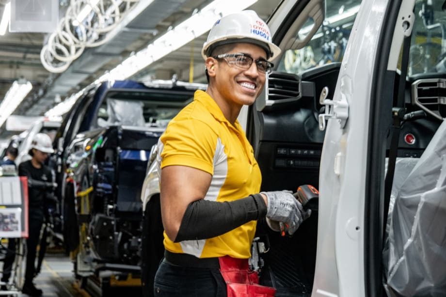Smiling auto assembly worker on the assembly line.