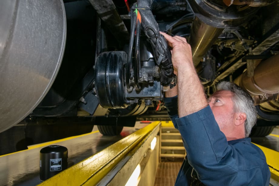 Mechanic working on a vehicle on a lift.