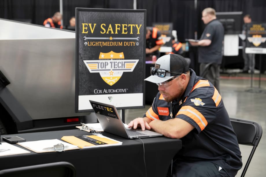 A man sitting at a table with a laptop computer, working on a project.