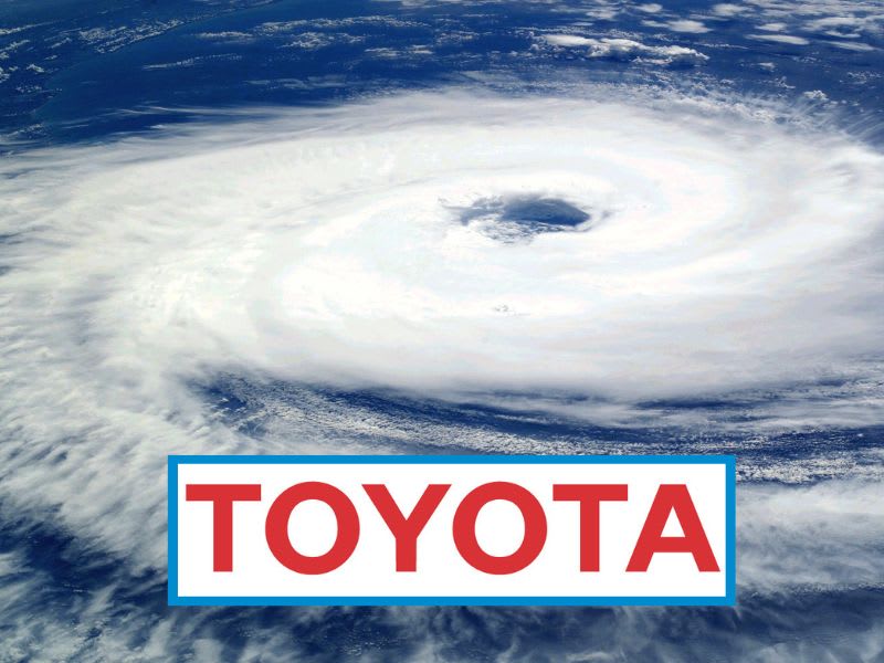 Toyota corporate logo in front of an image of a hurricane.