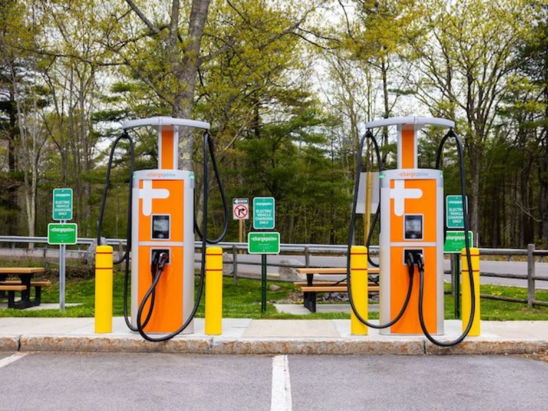 Two electric charging stations with orange and white signs.