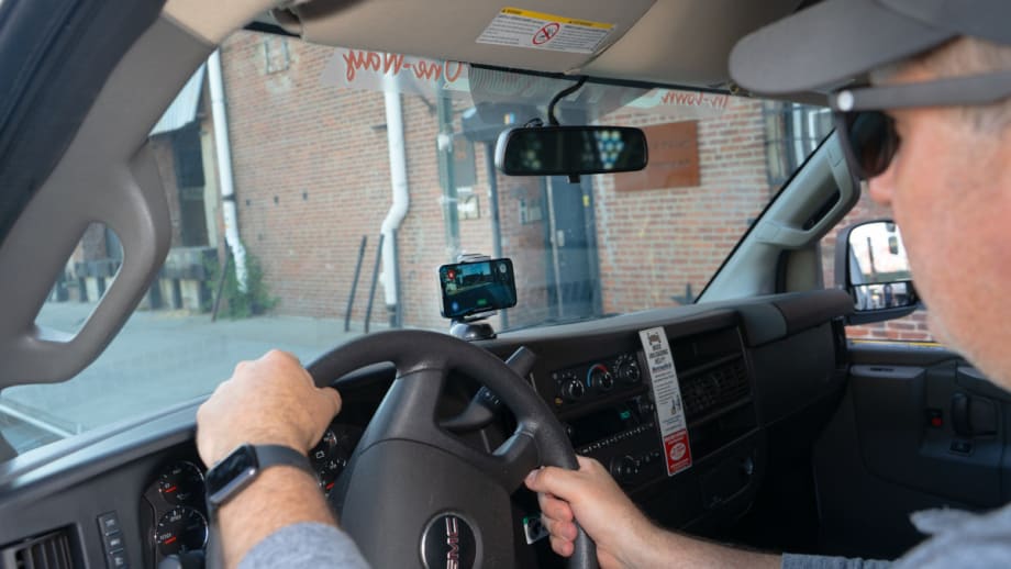 Image of a man behind the wheel of a truck with a dashboard camera in use.