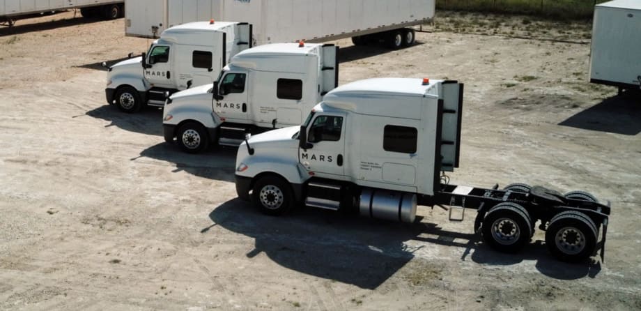 Three white trucks parked in a row