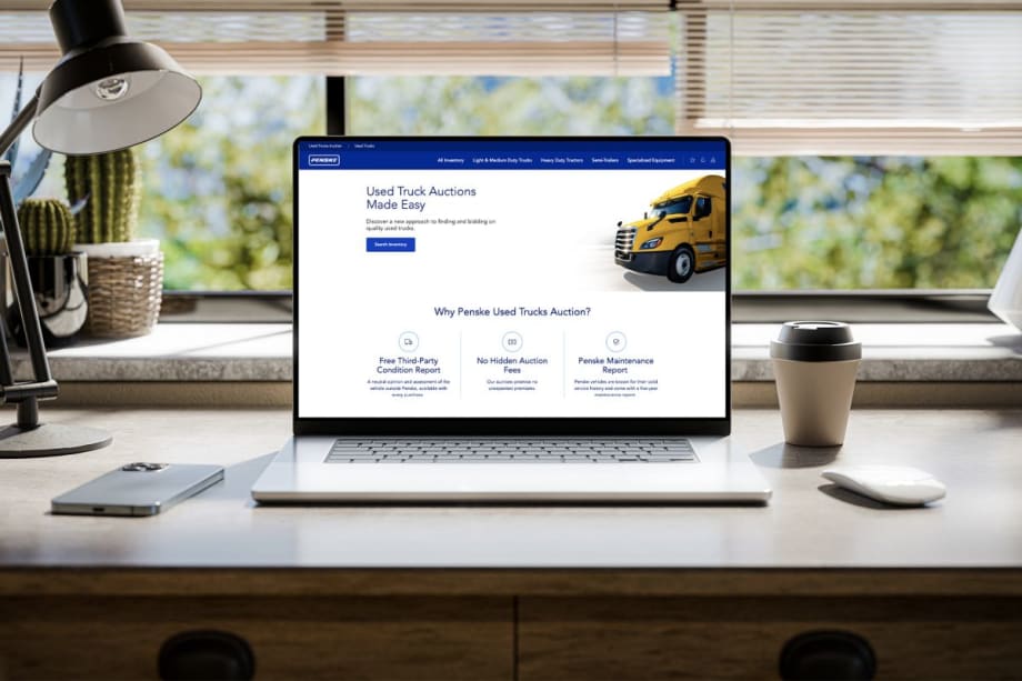 Laptop with Penske Used Truck auctions on screen