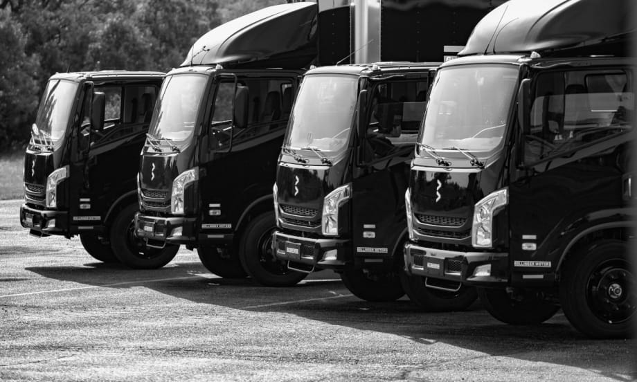 Angled view of cabs of four cargo trucks.