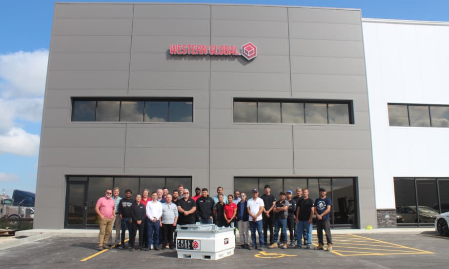 group standing in front of large industrial building