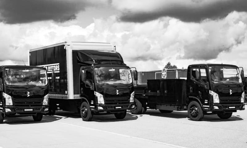 Black and white photo of three low cab forward Class 4 trucks.