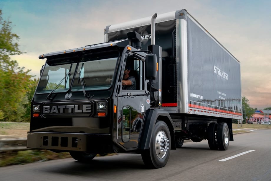 A black Class 6 box truck is shown on a road.