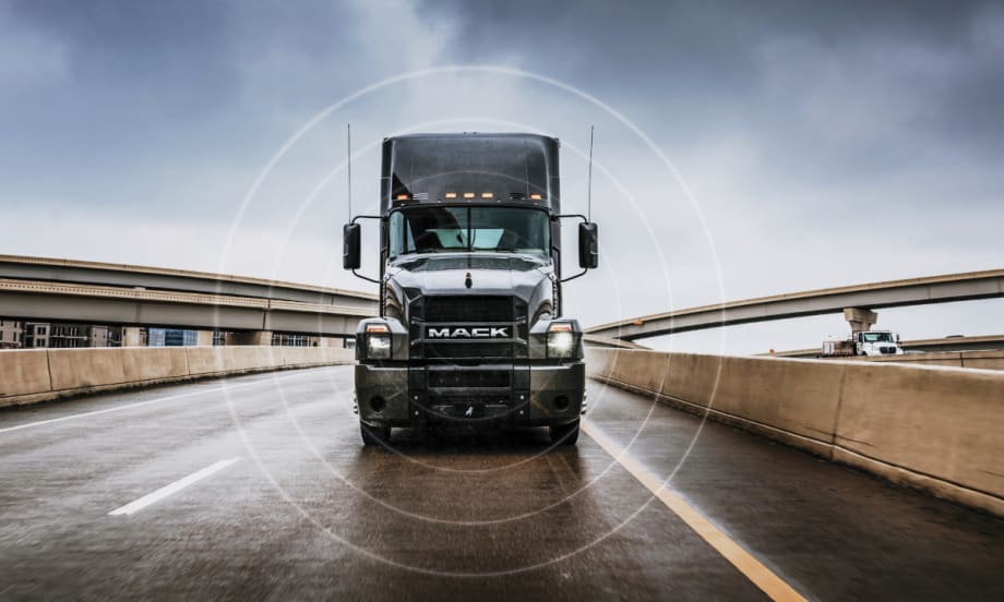 Black Mack Truck driving toward camera on highway.