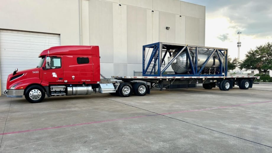 tractor trailer hauling  large equipment on a flatbed trailer.