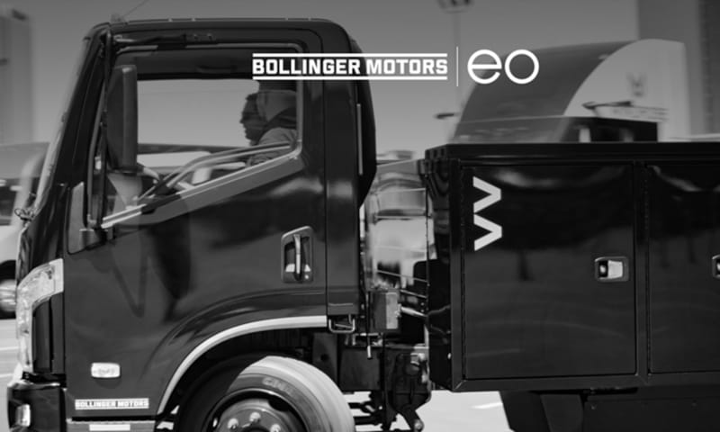 Photo of a black battery-elecdtric commercial truck with logos for EO Charging and Bollinger Motors.