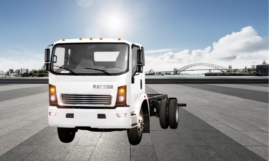 White low-cab forward truck against a parking lot scene.