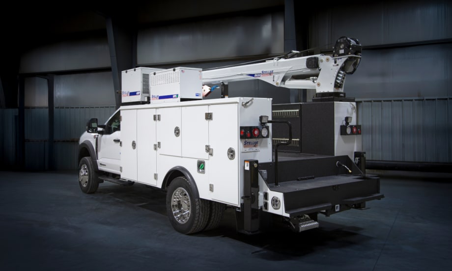 White service truck parked in a darkened industrial room.