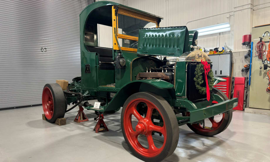 Antique Mack Truck from 1925 with green paint and red wheels.
