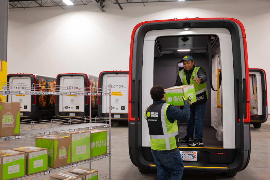 A Rivian electric van is loaded by a HelloFresh driver