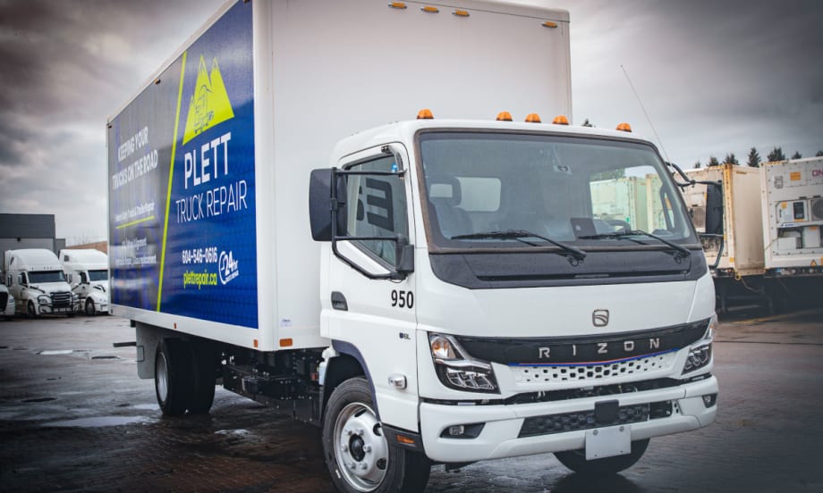 front quarter view of a medium-duty white electric truck with a box