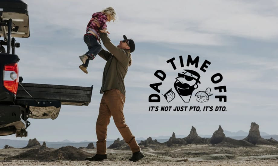 A dad lifts his child near a truck bed in a desert setting with the DECKED Dad Time Off logo and slogan: “It’s not just PTO, it’s DTO.”