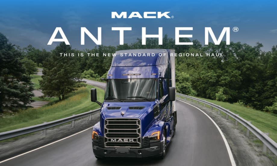 Mack tractor trailer driving on a road, shown from the front view.