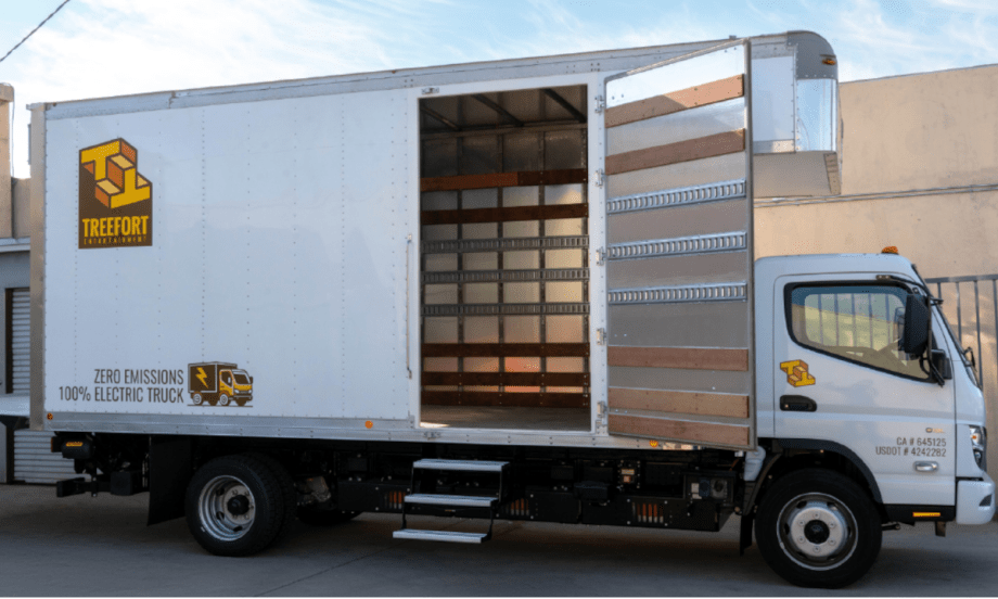 Medium-duty battery-electric box truck parked with side door open.