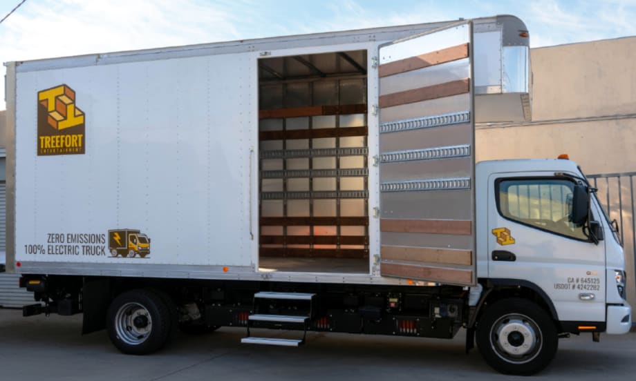 A white Treefort electric box truck with its side door open, showing an empty cargo area.