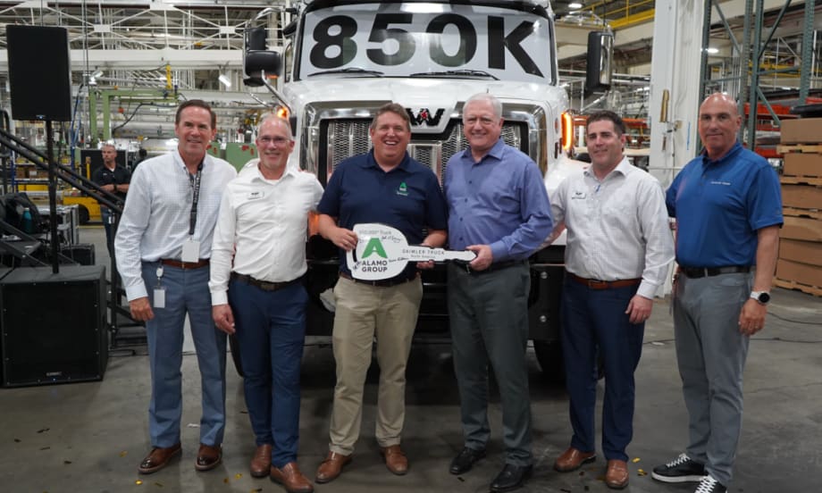 Six men stand in front of a Western Star truck marked “850K” at DTNA’s Cleveland plant, holding a ceremonial key for the 850,000th truck delivered to Alamo Group for snow and ice operations.