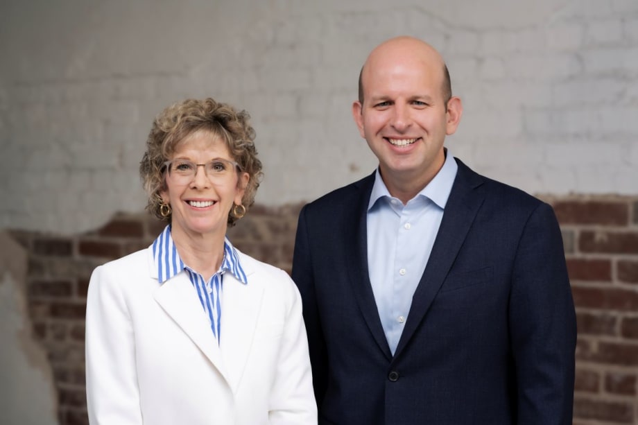 ArcBest's Judy McReynolds in white blazer next to Seth Runser in blue blazer.