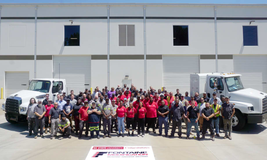Group photos of people standing in front of two commercial trucks parked in front of a building.