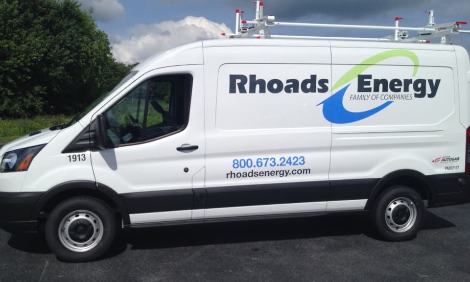 Photo of the side of a Ford Transit service van with company logo for Rhoads Energy.