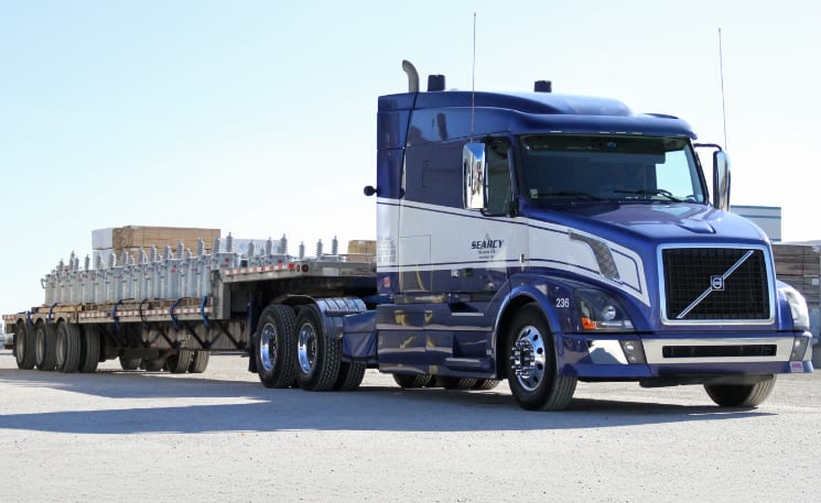 Photo of a Searcy truck pulling an open deck trailer