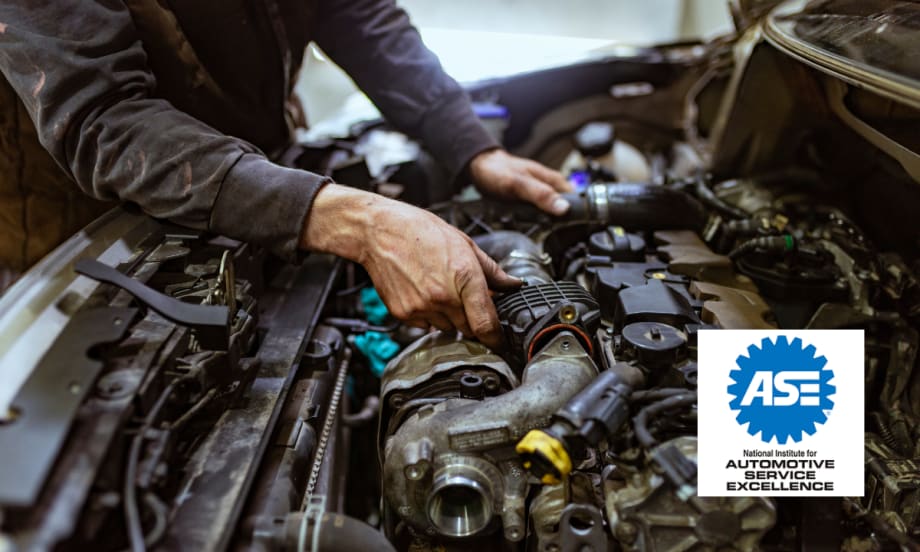 Mechanic working on an engine under the hood of a car with the ASE (National Institute for Automotive Service Excellence) logo in the foreground.