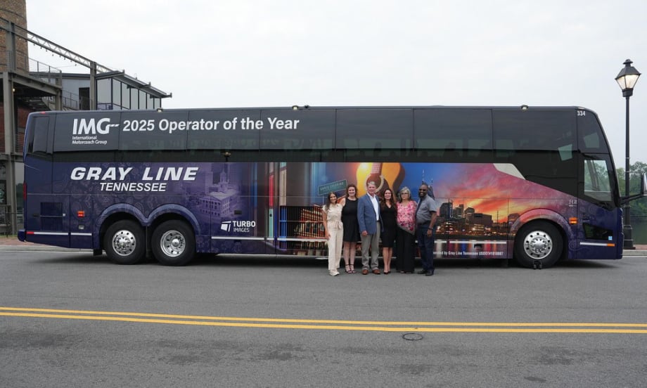 Gray Line Tennessee team poses in front of a custom motorcoach wrap celebrating the company’s recognition as 2025 IMG Operator of the Year.