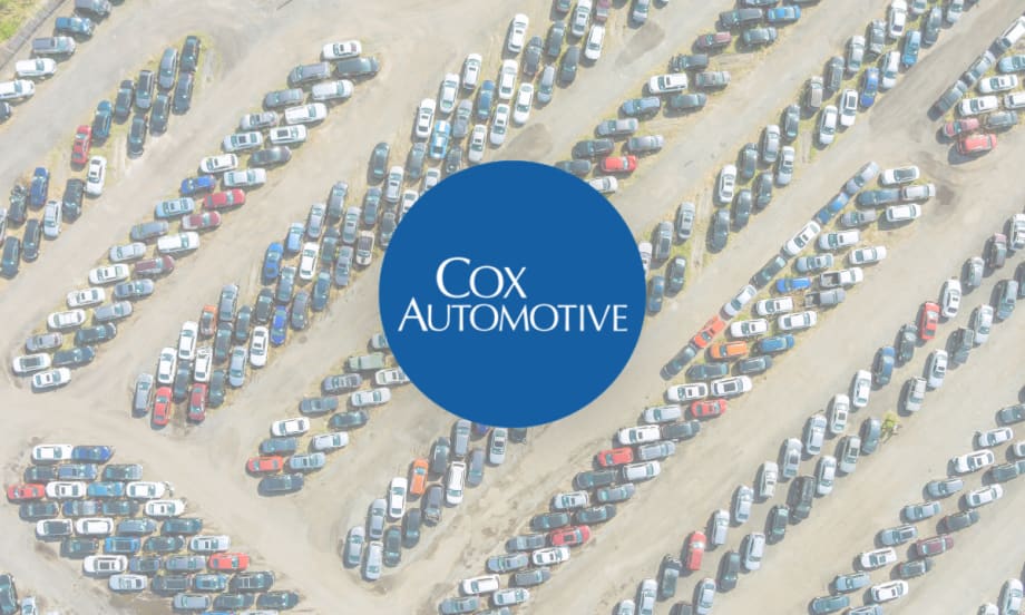 Cox Automotive logo overlay on aerial view of large auto auction lot filled with rows of parked vehicles.
