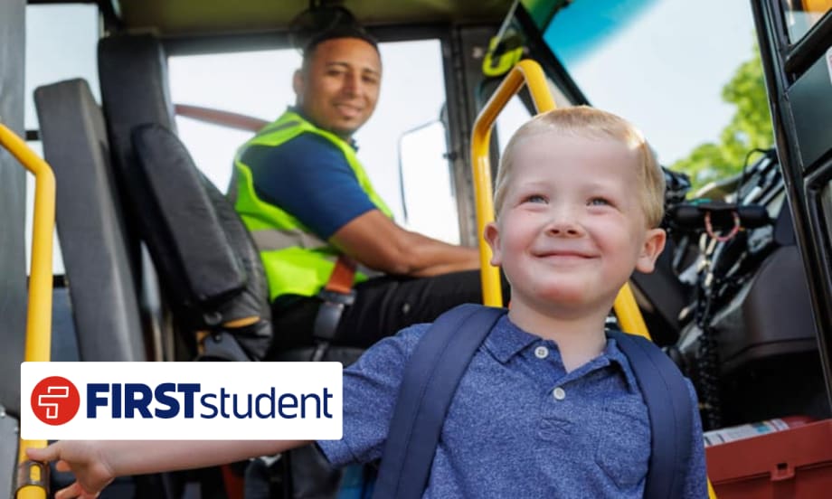 Young student boarding a school bus with driver in background, representing First Student’s new transportation partnership with Seneca Valley School District.