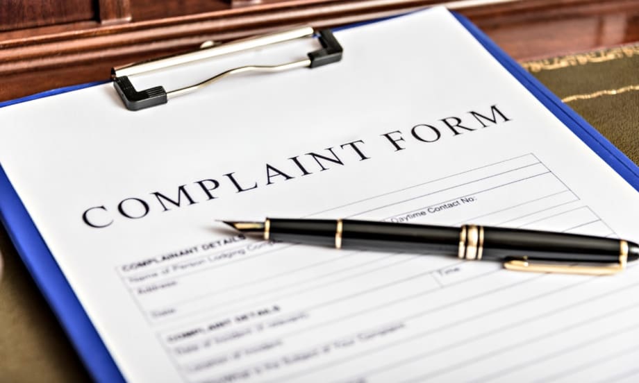 Complaint form on clipboard with black pen, ready for filing a formal written complaint