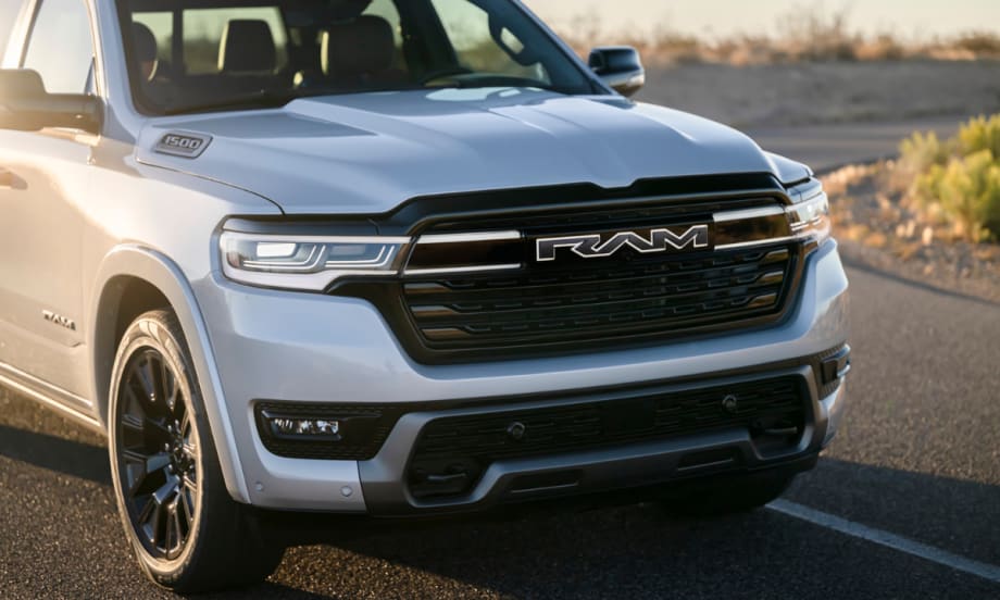 Front view of the Ram 1500 REV electric pickup in silver, showing bold RAM grille and headlights. The range-extended truck replaces Ram’s BEV plans, offering strong towing, payload, and range.
