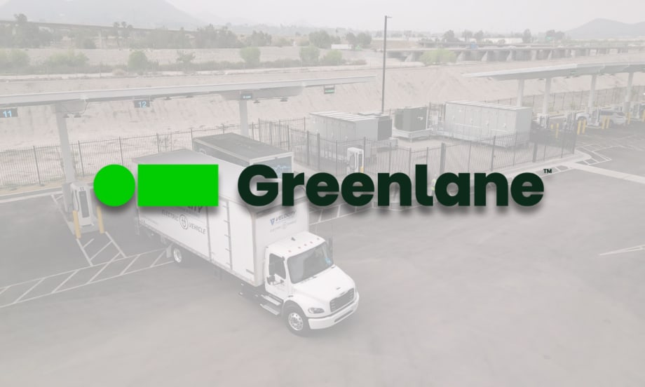 Greenlane logo overlaid on a picture of a Velocity electric truck parked at Greenlane’s Colton, California charging site with multiple charging stations visible.
