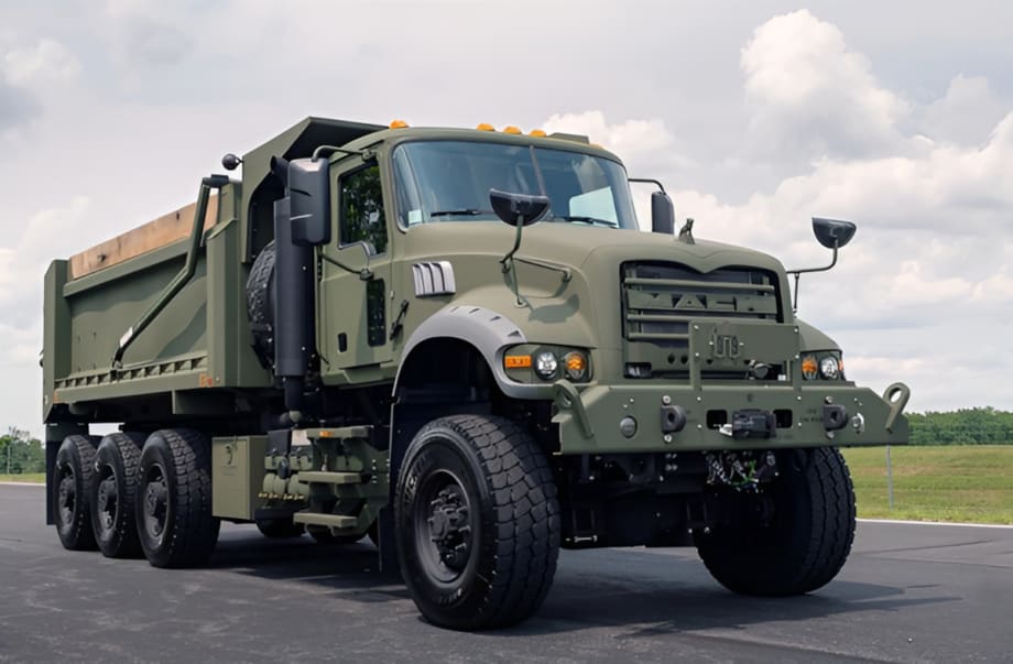 Military dump truck shown from the front quarter low angle.