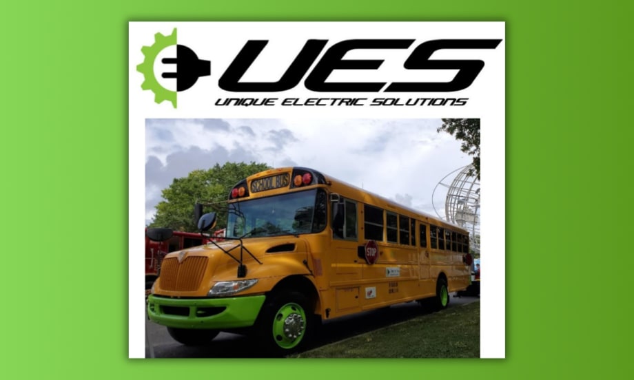 A repowered electric school bus with green wheels and accents, designed by Unique Electric Solutions, parked outdoors under cloudy skies with the company’s logo displayed above the image.