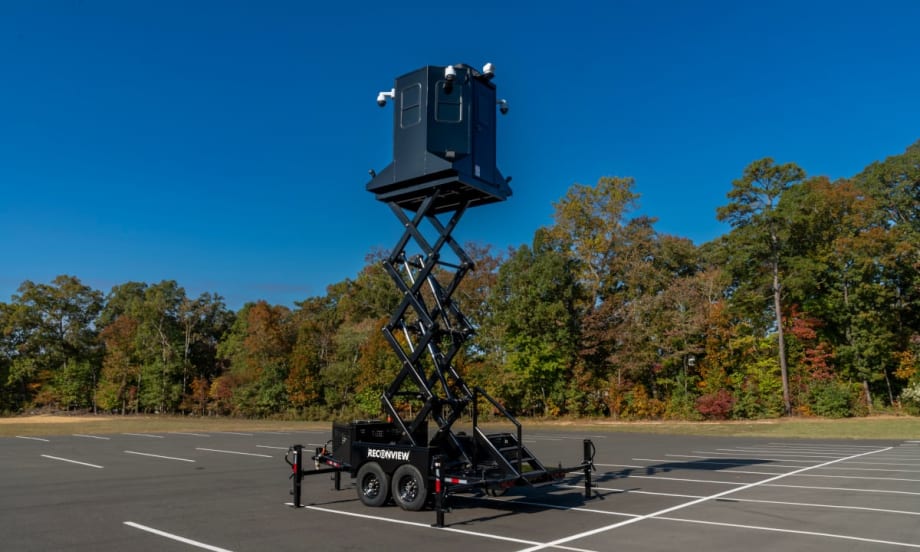 view of a mobile observation trailer deployed in a parking lot against a blue sky